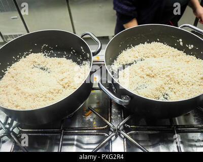 Erste Schritte des Risotto Rezept : gerösteter Reis und gute Brühe, und Weißwein Stockfoto