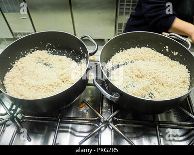 Italienischen Chefkoch Zubereitung risotto klassische italienische Reisgericht mit asparagi und Pilze Stockfoto