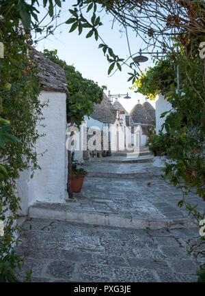 Ansicht der traditionellen weißen Trockenmauern Trulli auf einer Straße im Stadtteil Monti Bereich von Alberobello in Apulien, Italien. Stockfoto