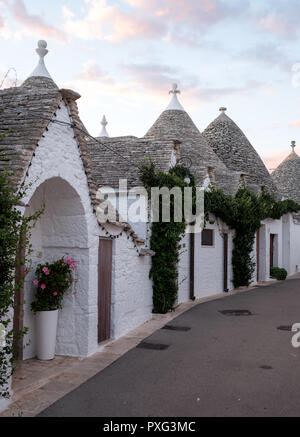 Ansicht der traditionellen weißen Trockenmauern Trulli auf einer Straße im Stadtteil Monti Bereich von Alberobello in Apulien, Italien. Stockfoto