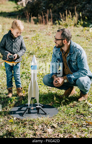 Gerne Vater und Sohn starten Modell rocket Outdoor Stockfoto