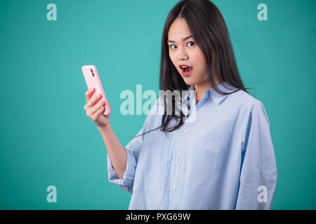 Junge asiatische Frau Gestik in Defferent Posen über blauer Hintergrund