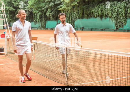 Tennis Spieler mit hölzernen Schläger gehen nach dem Training in der Nähe von Netto auf Gericht Stockfoto