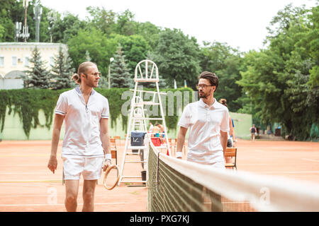 Tennis Spieler mit hölzernen Schläger zu Fuß in der Nähe von Netto auf Gericht Stockfoto