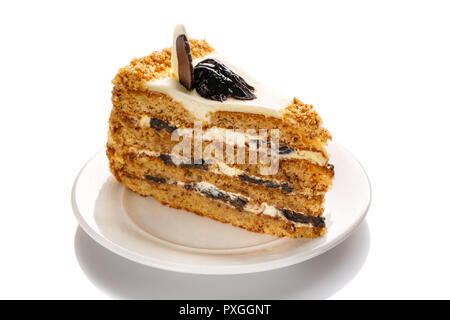 Ein Stück Kuchen mit Honig und Trockenpflaumen, die mit einem weißen Hintergrund hervorgehoben Stockfoto