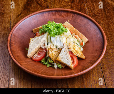 Die Schale mit Schweinefleisch, Tomaten und Croutons Stockfoto