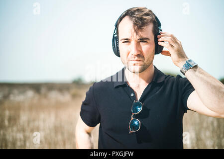 Jungen attraktiven Mann mit schwarzen Musik auf seinem Kopfhörer Stockfoto