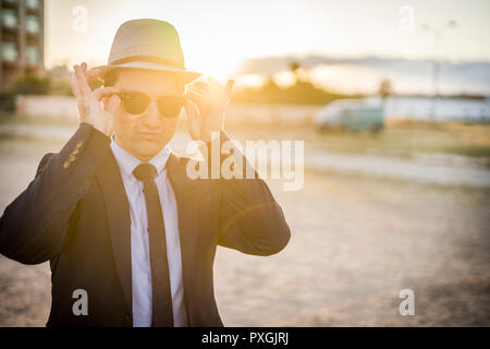 Lifestyle Portrait von Vintage suchen junger Mann in Anzug und Sonnenbrille bei Sonnenuntergang Stockfoto