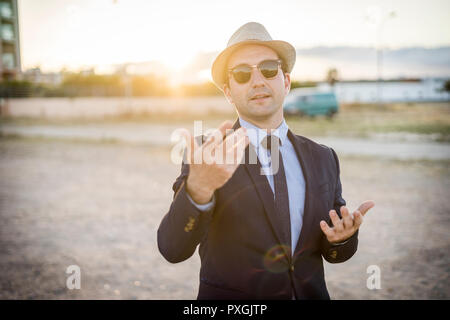 Lifestyle Portrait von Vintage suchen junger Mann in Anzug und Sonnenbrille bei Sonnenuntergang Stockfoto