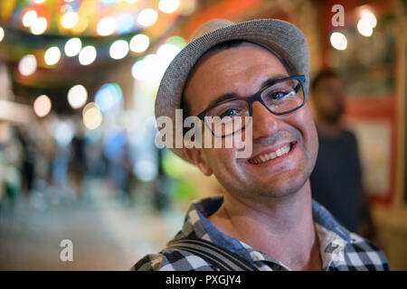 . Glückliche junge Mann Portrait, Outdoor in der Nacht in den städtischen Einstellungen Stockfoto