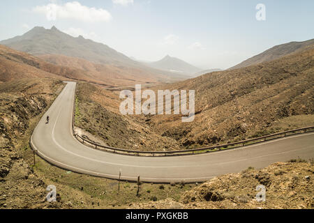 Panoramablick über kurvenreiche Straße mit Radfahrern in astronomischer Sicht der Sicasumbre, Fuerteventura, Spanien. Stockfoto