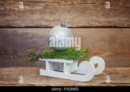 Weihnachten Neujahr Zusammensetzung winter Objekte Kugeln und Schlitten auf alten schäbigen Möbeln im Landhausstil Hintergrund. Weihnachten Urlaub Dezember Dekoration kopieren. Zeit Stockfoto