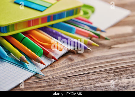 Schreibwaren unter einem hellen Notebook auf dem Tisch Stockfoto