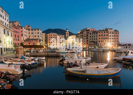 Ruhigen Hafen mit Fischerbooten, Rom, Italien im Abendlicht mit Reflexionen über die Lichter der traditionelle bunte waterfront Gebäude Stockfoto