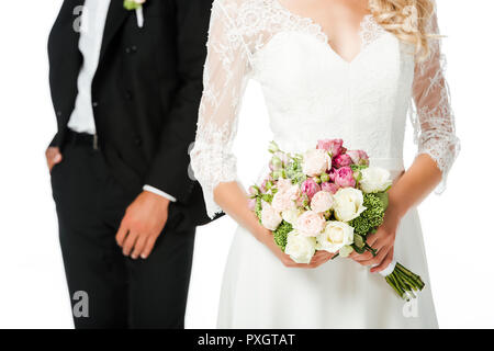 7/8 shot der Braut mit Blumenstrauß und Bräutigam isoliert auf weißem Stockfoto