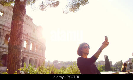 Frau nimmt eine selfie vor der majestätischen Kolosseum in Rom Stockfoto