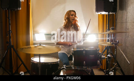 Rothaarige Mädchen sitzt hinter einem im Studio drum Set Stockfoto