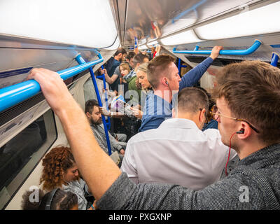 Pendler auf überfüllten Londoner U-Bahn im Berufsverkehr, Großbritannien Stockfoto