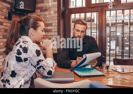 Junge Geschäftsleute zusammen Arbeiten auf Papier arbeiten und sprechen über Berichte und Finanz im Cafe. Stockfoto