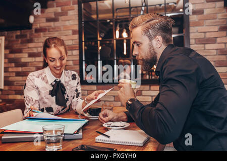 Junge Geschäftsleute zusammen Arbeiten auf Papier arbeiten und sprechen über Berichte und Finanz im Cafe. Stockfoto
