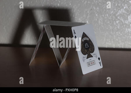 Karten auf einem Schreibtisch aus Holz mit dem Ace card Lehnen und der Schatten, er wirft gestapelt Stockfoto