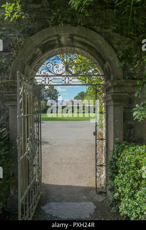 Arch und Metal Gate aus dem ummauerten Garten auf Garnish Island, County Cork, Irland in Richtung der Italienischen Teestube und Garten. Stockfoto