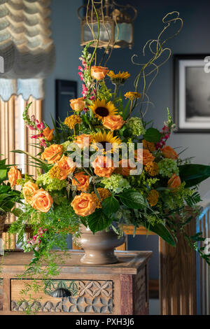 Ein Blumenstrauß in einer Vase tan. Pfirsich Rosen und Sonnenblumen. Stockfoto