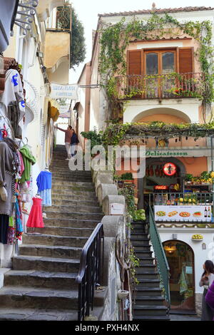 Reisende gehen auf den schmalen, steilen Straße in Positano, ein am Berghang gelegenes Dorf am südlichen Italys Amalfi Küste Stockfoto