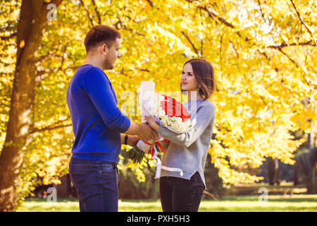 Mann gibt einen Blumenstrauß für seine Frau Stockfoto