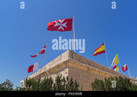 Viele verschiedene Flaggen über die Stadt von Portomaso, Malta gegen den blauen Himmel, der Wind bläst winken Stockfoto