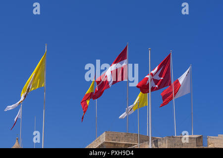 Viele verschiedene Flaggen über die Stadt von Portomaso, Malta gegen den blauen Himmel, der Wind bläst winken Stockfoto