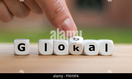 Hand dreht einen Würfel und Änderungen das Wort lokal bis global Stockfoto