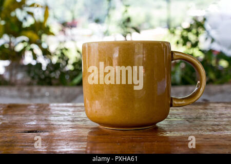 Eine Tasse Kaffee auf hölzernen Tisch über die Natur Hintergrund. Stockfoto