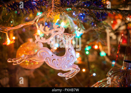 Weihnachten Spielzeug Hirsche hängen an funkelnden Weihnachtsbaum. Stockfoto