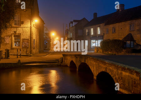 Dunst und Nebel im Morgengrauen in der cotswold Dorf Bourton auf dem Wasser im Herbst. Bourton auf dem Wasser, Cotswolds, Gloucestershire, England Stockfoto