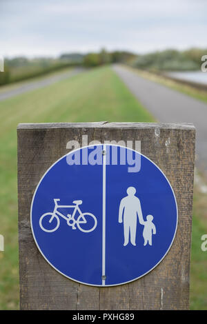 Rundschreiben gemeinsames Radfahren und Wandern Schild mit weißer Schrift auf blauem Hintergrund auf einem hölzernen Pfosten mit Pfad Straße im Hintergrund Stockfoto