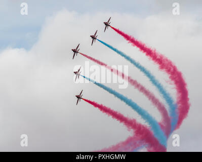 Die roten, weißen und blauen Rauch Trails von die roten Pfeile aerobatic Display Team im Flug über Highclere Castle, Berkshire, England Stockfoto