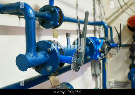 Absperrschieber installiert an Rohren in blau lackiert. Industrielle Hintergrund. Stockfoto