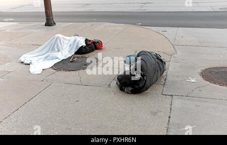 Zwei obdachlose Männer schlafen auf einem Downtown Cleveland, Ohio Street im späten Herbst Chill. Stockfoto
