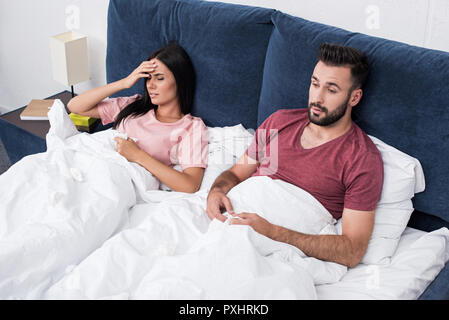 Hohe Betrachtungswinkel der Jungen kranken Paar im Bett sitzen Stockfoto