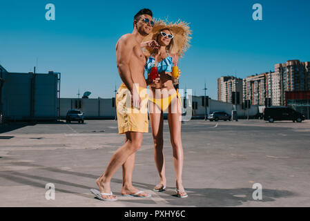 Junges Paar am Strand Kleidung mit erfrischenden Cocktails stehen auf Parkplatz Stockfoto