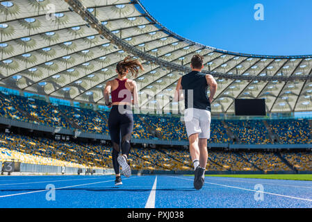 Ansicht der Rückseite des männlichen und weiblichen Jogger laufen auf der Strecke in Stadion Stockfoto