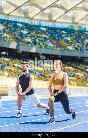 Junge sportliche Paar Aufwärmen vor dem Training auf der Laufbahn im Stadion Stockfoto