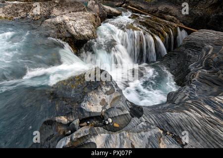 Den Kicking Horse River fließt von den Bergen herab, wurde zu einem Wasserfall, bevor es unter einer natürlichen Brücke geht, Yoho National Park, British Columbi Stockfoto