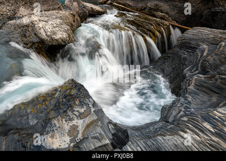 Den Kicking Horse River fließt von den Bergen herab, wurde zu einem Wasserfall, bevor es unter einer natürlichen Brücke geht, Yoho National Park, British Columbi Stockfoto