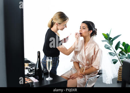 Seitenansicht des Make-up-artist Anwendung Lippenstift auf Bräute Lippen Stockfoto