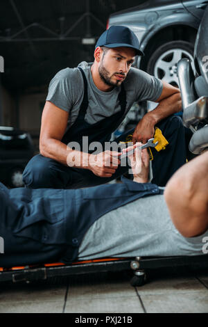 Professionelle Ingenieure arbeiten mit Werkzeugen in Werkstatt Stockfoto