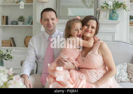 Happy Family umarmen und lächelnd. Mutter, Vater, Kind Tochter zu Hause Stockfoto