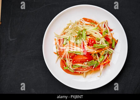 Von Thai Essen om tum' oder grüne Papaya Salat gemischt mit Thai traditionelle Zutat und Soße mit roten Chili, Tomate, lange Bohnen, Karotten. Berühmte würzige foo Stockfoto