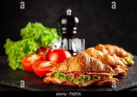 Klassische BLT croissant Sandwiches auf dunklem Hintergrund Stockfoto